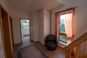 a living room with a chair and a window at Ferienhaus bis 10 Personen und 2,5 Schlafzimmern in Geisenheim
