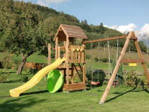 a playground with a slide and a swing set at Tischlergut in Leogang