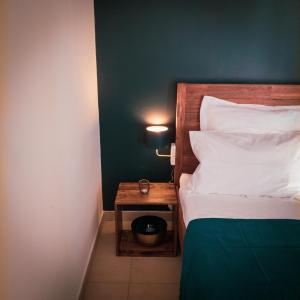 拉波瑟松的住宿－Bleu Nuit，一间卧室配有一张床和一个床头柜,上面有时钟
