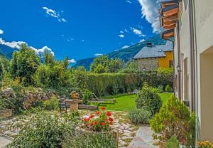 un jardín con flores y una casa de fondo en Hotel Plaza en Castejón de Sos