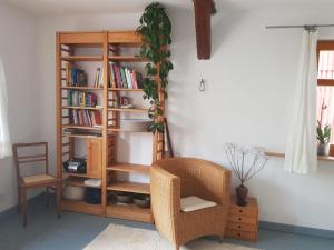 Habitación con estante para libros y silla en Ältestes Haus in Quentel - Ferienwohnung 2 mit Dachterrasse, en Lichtenau