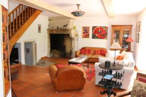 ein Wohnzimmer mit einem Sofa und einem Kamin in der Unterkunft Les Chenevières in Culey