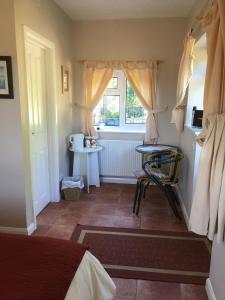 a bedroom with a bed and a window and a table at Rosemary Cottage in Hooe