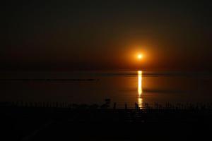 - un coucher de soleil sur l'eau avec une plage dans l'établissement ZIP Apartments, à Mamaia