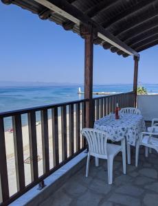 a table and chairs on a balcony overlooking the beach at Seafront Apartment Pefkochori in Pefkohori