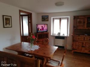 a living room with a wooden table and a television at Clou Accomodation in Aosta