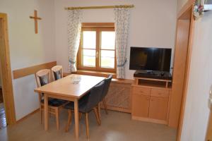 ein Esszimmer mit einem Tisch und einem TV in der Unterkunft Ferienwohnung Ertlerhof in Ranten