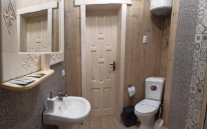 a bathroom with a white toilet and a sink at Котедж "Солард" in Yaremche