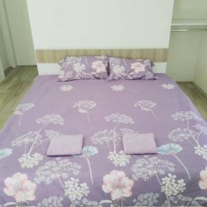 a bed with a purple blanket with flowers on it at The Brothers Villa Hotel in Ohrid