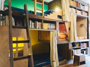 Etagenbett in einem Zimmer mit Bücherregalen in der Unterkunft Onomichi Guest House Anago-no-Nedoko in Onomichi