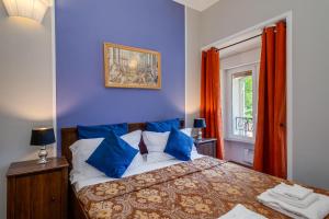 Un dormitorio con una cama con paredes azules y una ventana en Raphael Rooms, en Roma