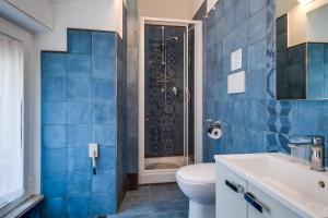ローマにあるRaphael Roomsの青いタイル張りのバスルーム(トイレ、シャワー付)