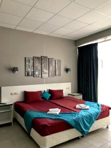 ルーガにあるHotel Globusのベッドルーム1室(赤と青のシーツが備わる大型ベッド1台付)