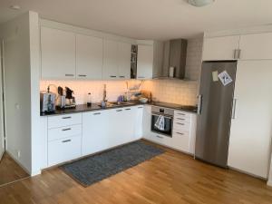uma cozinha com armários brancos e um frigorífico de aço inoxidável em Fjällhus 1 em Höstsätern