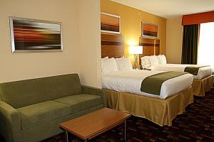 a hotel room with two beds and a couch at Holiday Inn Express Fort Lauderdale Airport South by IHG in Dania Beach