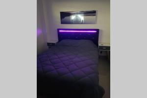 een slaapkamer met een bed met een paars licht bij Appartement front Vieux Port tout option jacuzzi in Marseille