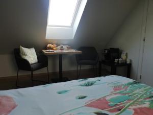 Langemark的住宿－B&B Lora，一间卧室配有一张床和一张桌子及椅子
