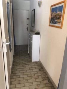 un corridoio con pavimento piastrellato in una camera di Studio 27m2 proche de la plage a Le Grau-du-Roi