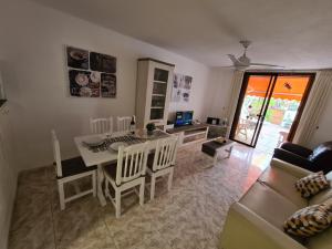 un soggiorno con tavolo, sedie e divano di Duplex Parque Santiago 2 close to pool, sea + beach, central, Wifi, heated pool a Playa de las Americas