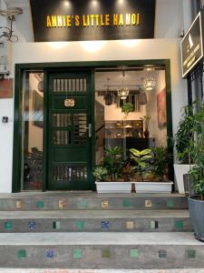 a store front with a green door and some plants at Annie's Little Hanoi in Hanoi