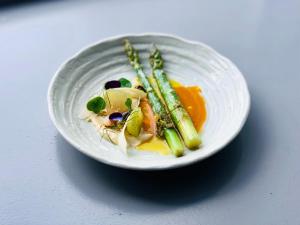 un piatto di cibo con asparagi su un tavolo di The Newport Restaurant with Rooms a Newport-On-Tay