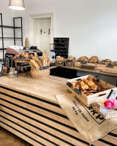 a counter with baskets of bread and baskets of pastries at Amira Apartman in Komárno