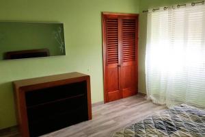 a room with a fireplace and a wooden door at Casa dos cinco sentidos in Feteira Pequena