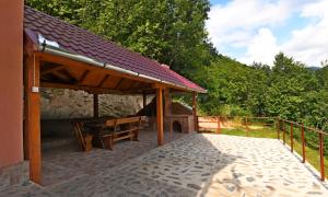 un padiglione in legno con panca su un patio di Cabana Oana Retezat a Râu de Mori