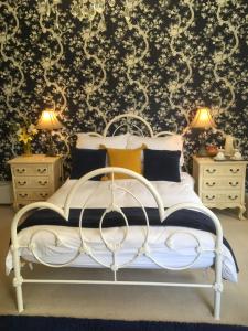 1 dormitorio con cama blanca y papel pintado en blanco y negro en Littlebank Country House en Settle