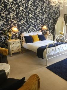 1 dormitorio con 1 cama con papel pintado azul y blanco en Littlebank Country House, en Settle