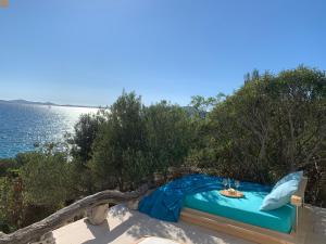 łóżko w piasku obok wody w obiekcie Holiday Home Pure Nature w mieście Tkon