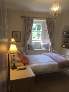 1 dormitorio con 1 cama y 1 mesa con lámpara en Littlebank Country House, en Settle