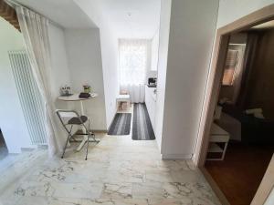 a white hallway with a table and a chair at Casa Bella in Ponti Sul Mincio