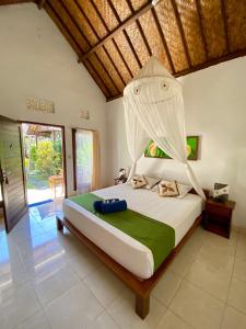 a bedroom with a large bed with a canopy at Radya Homestay in Nusa Lembongan