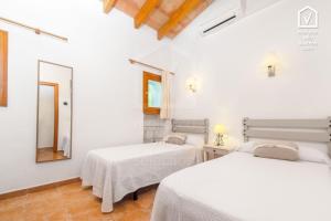 two beds in a white room with a mirror at E323 Moli Den Fanals by Mallorca Villa Selection in Alcudia