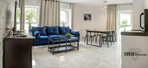 a living room with a blue couch and a table at Corso No 7 APARTMENT in Szczawno-Zdrój