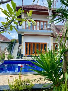 a villa with a swimming pool in front of a house at Radya Homestay in Nusa Lembongan