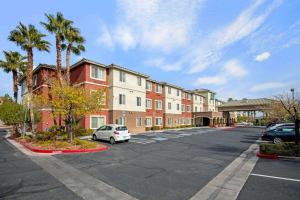 un parcheggio di fronte a un edificio con palme di La Quinta by Wyndham Las Vegas RedRock/Summerlin a Las Vegas