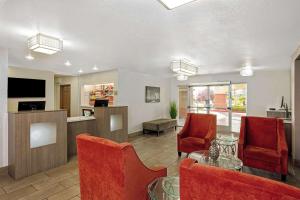 a living room with red chairs and a table at La Quinta by Wyndham Las Vegas RedRock/Summerlin in Las Vegas