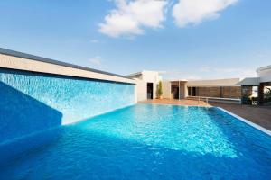 a swimming pool in front of a house at Wyndham Grand Athens in Athens