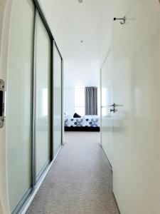 a hallway with glass doors leading to a bedroom at Ultra Modern Room in London