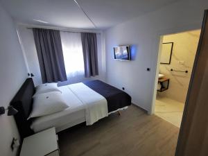 a hotel room with a bed and a window at SPA Apartment Vito in Vodice