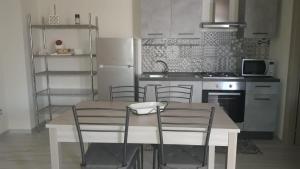 eine Küche mit einem Tisch und Stühlen sowie einem Kühlschrank in der Unterkunft Villa Maria in Marconia