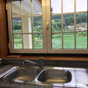 a sink in a kitchen with two windows at Casa do Reguengo in Arouca +65 photos
