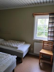 1 Schlafzimmer mit 2 Betten und einem Fenster in der Unterkunft Ekesberget Stugby stuga 10 in Ekshärad