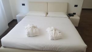 ein weißes Bett mit zwei weißen Handtüchern darauf in der Unterkunft Hotel Cristallo in Udine