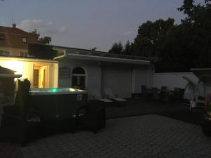 a house with a hot tub in the backyard at night at Márvány Panzió in Hajdúszoboszló