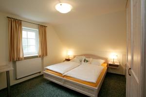 a bedroom with a large white bed with two lamps at Berggasthof zur Glocke in Winterberg