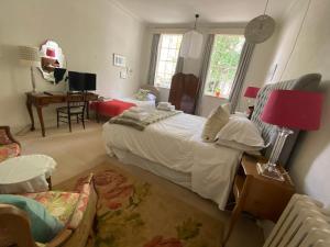 a bedroom with a bed and a desk and a chair at Baye House in Colchester