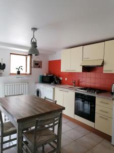 a kitchen with a wooden table and a kitchen with white cabinets at gîte des Hortensias in Raon-aux-Bois